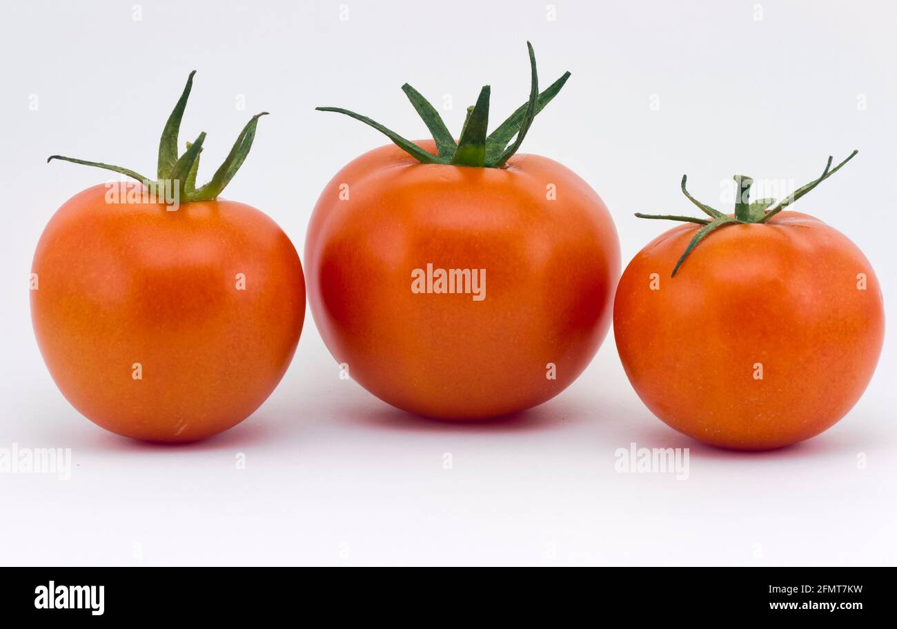three red tomato vegetable isolated on white background Stock Photo - Alamy