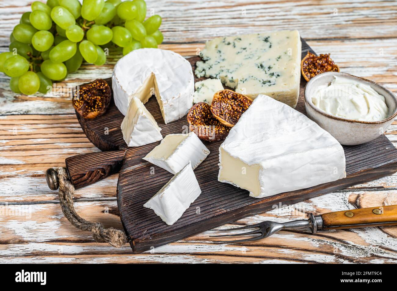 Cheese board with brie, Camembert, Gorgonzola and blue creamy cheese. White wooden background. Top view Stock Photo - Alamy