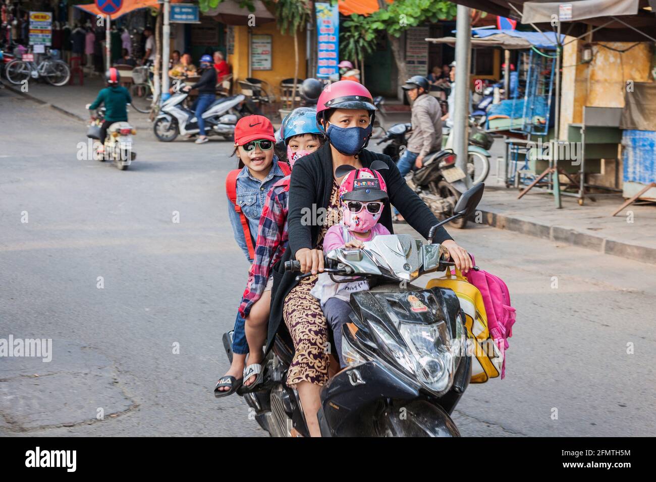 Family of four people crammed on scooter, Hoi An, Vietnam Stock Photo