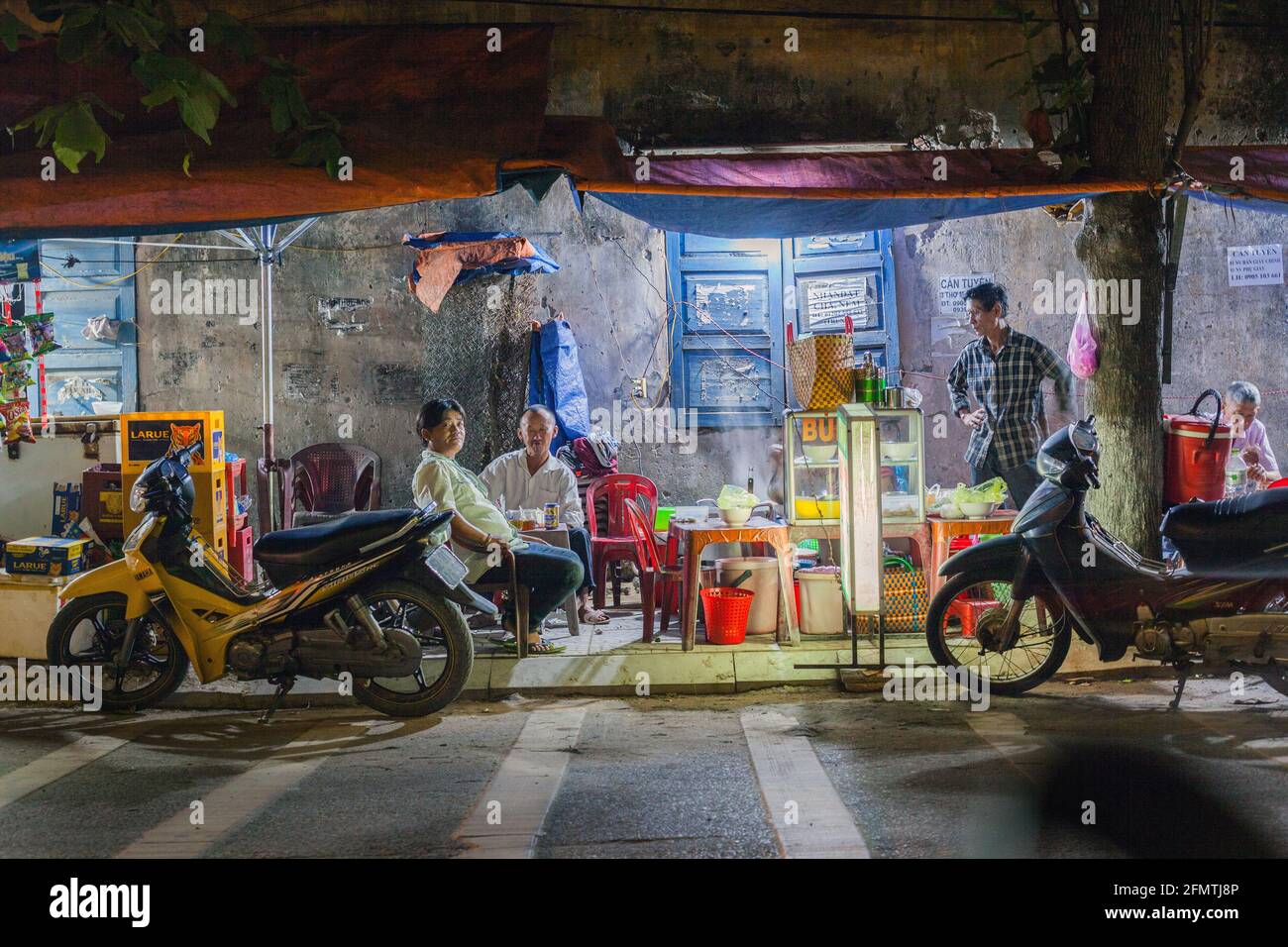 Vietnamese males seated at ambient roadside cafe after dusk, Hoi An, Vietnam Stock Photo Alamy