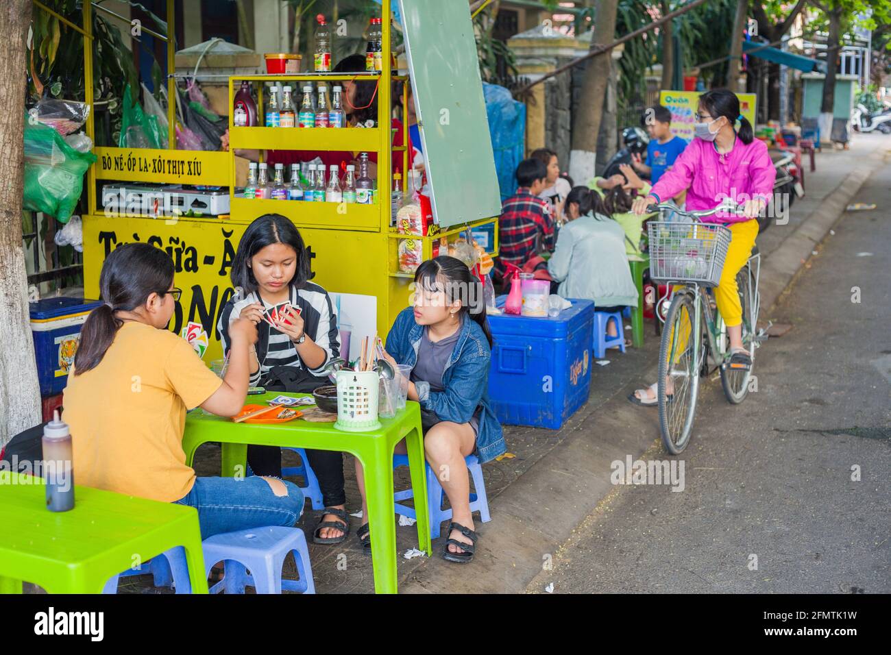 Vietnamese children playing card game "Uno" at pavement cafe, Hoi An
