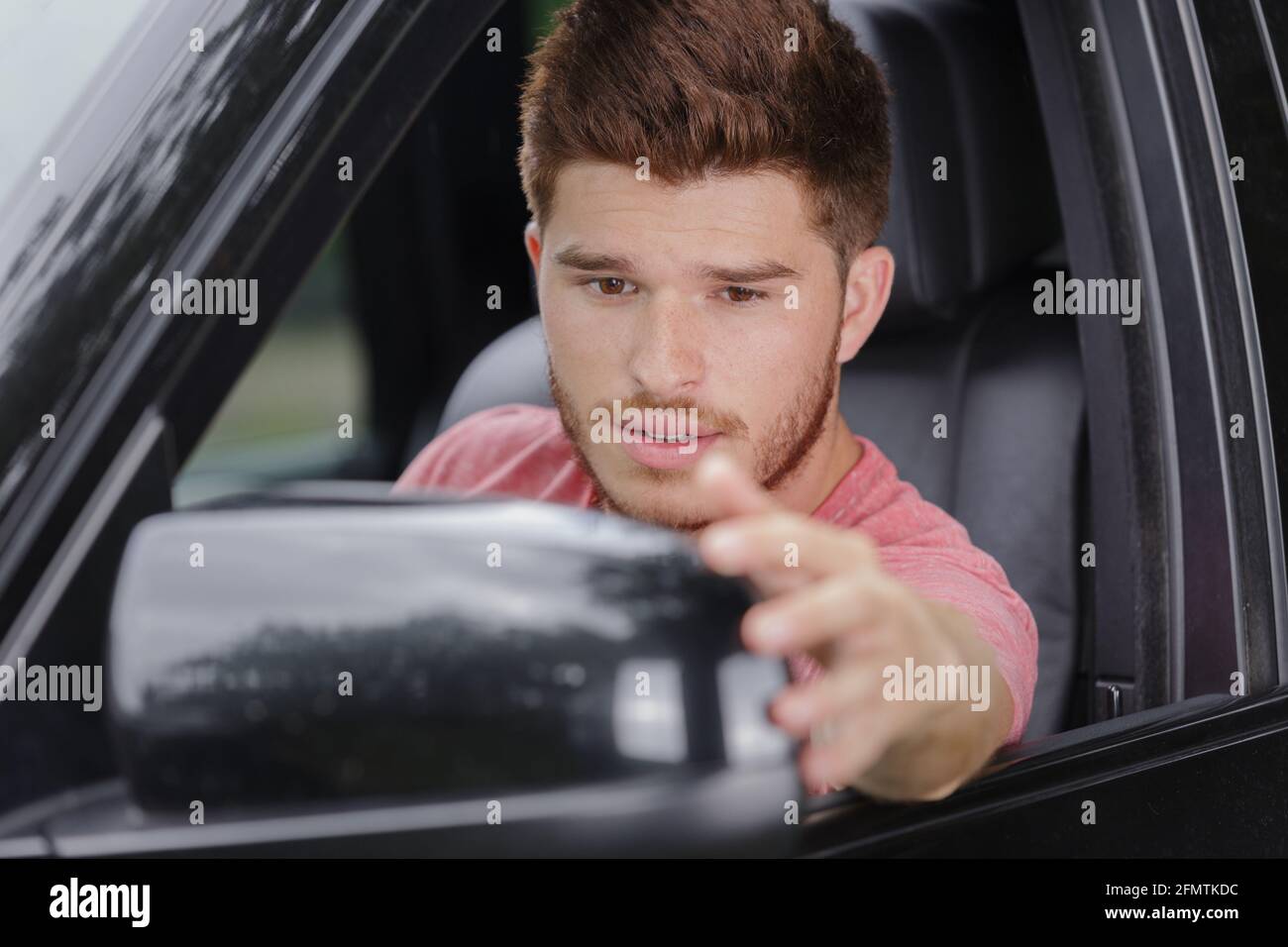 man adjusting side car mirror Stock Photo Alamy