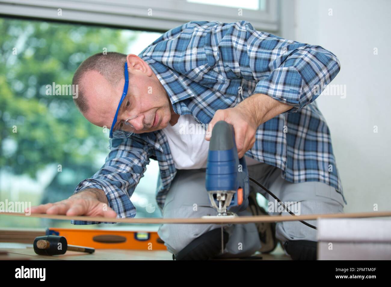floor installer cutting the floorboard with jigsaw Stock Photo Alamy
