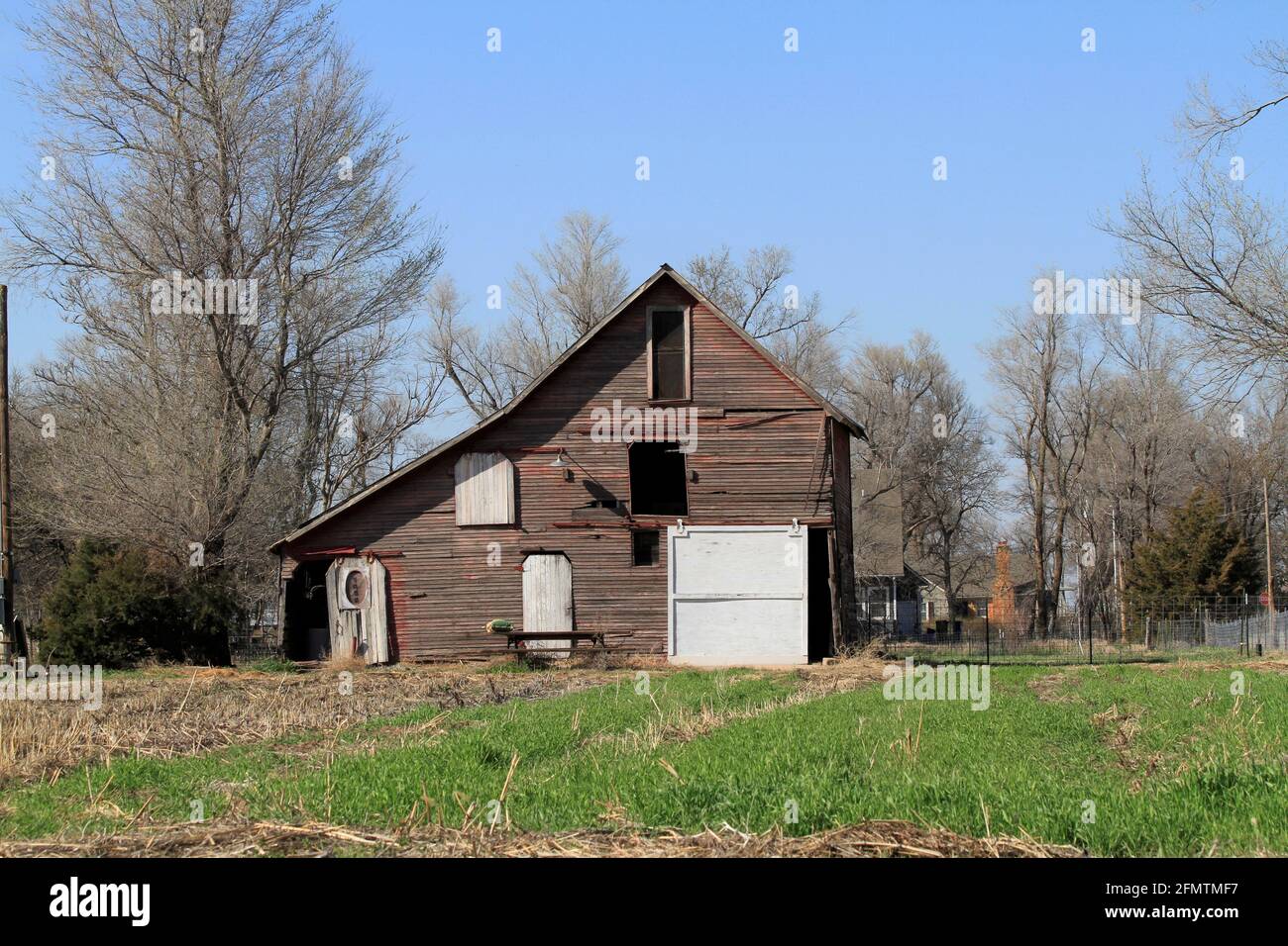 Kansas wooden barn with grass, tree's and blue sky on a colorful day. Stock Photo
