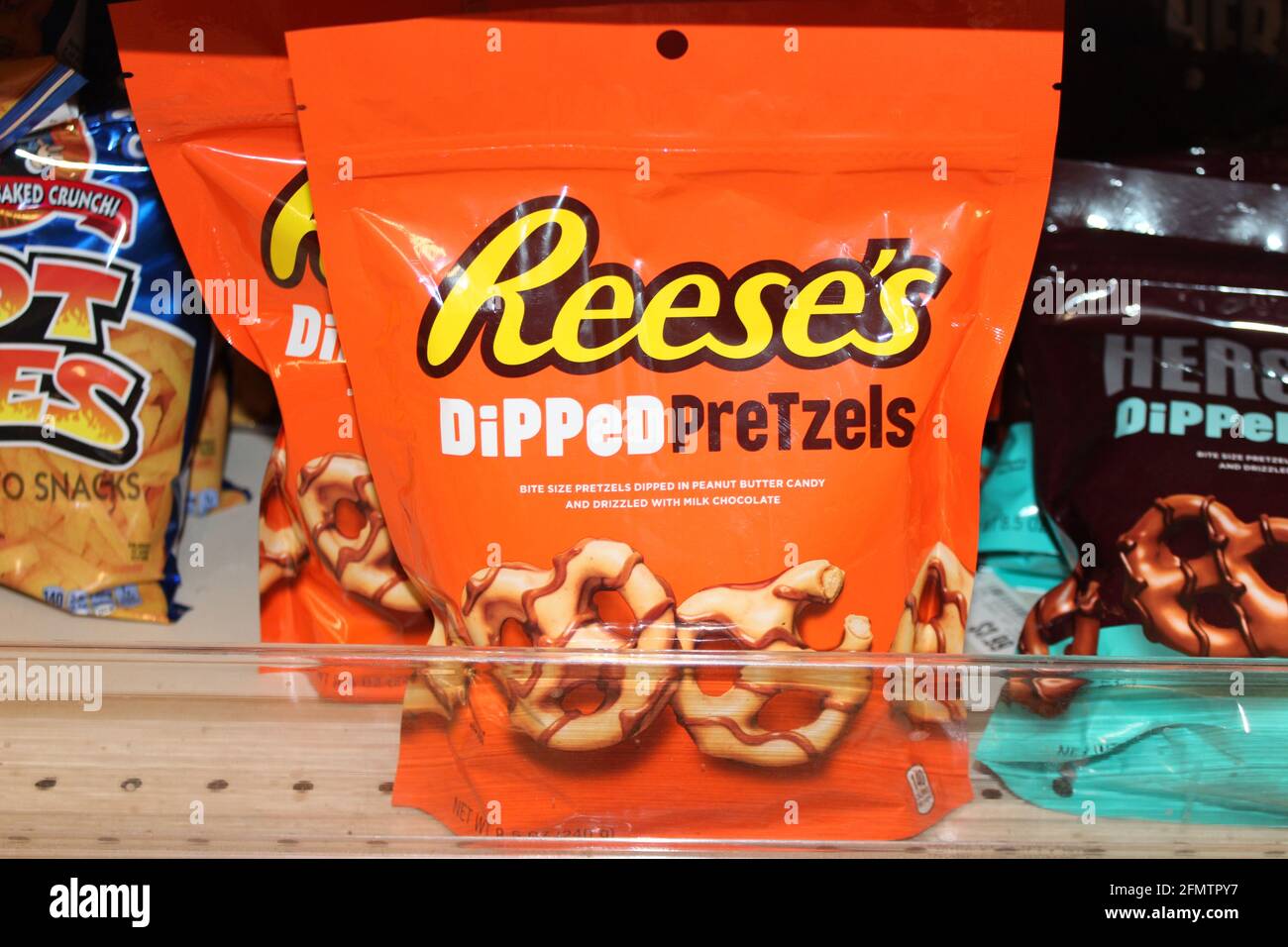 Reese's Dipped Pretzel's shot closeup in an orange package that's bright and colorful on a metal shelf that's at a grocery store in Kansas. Stock Photo