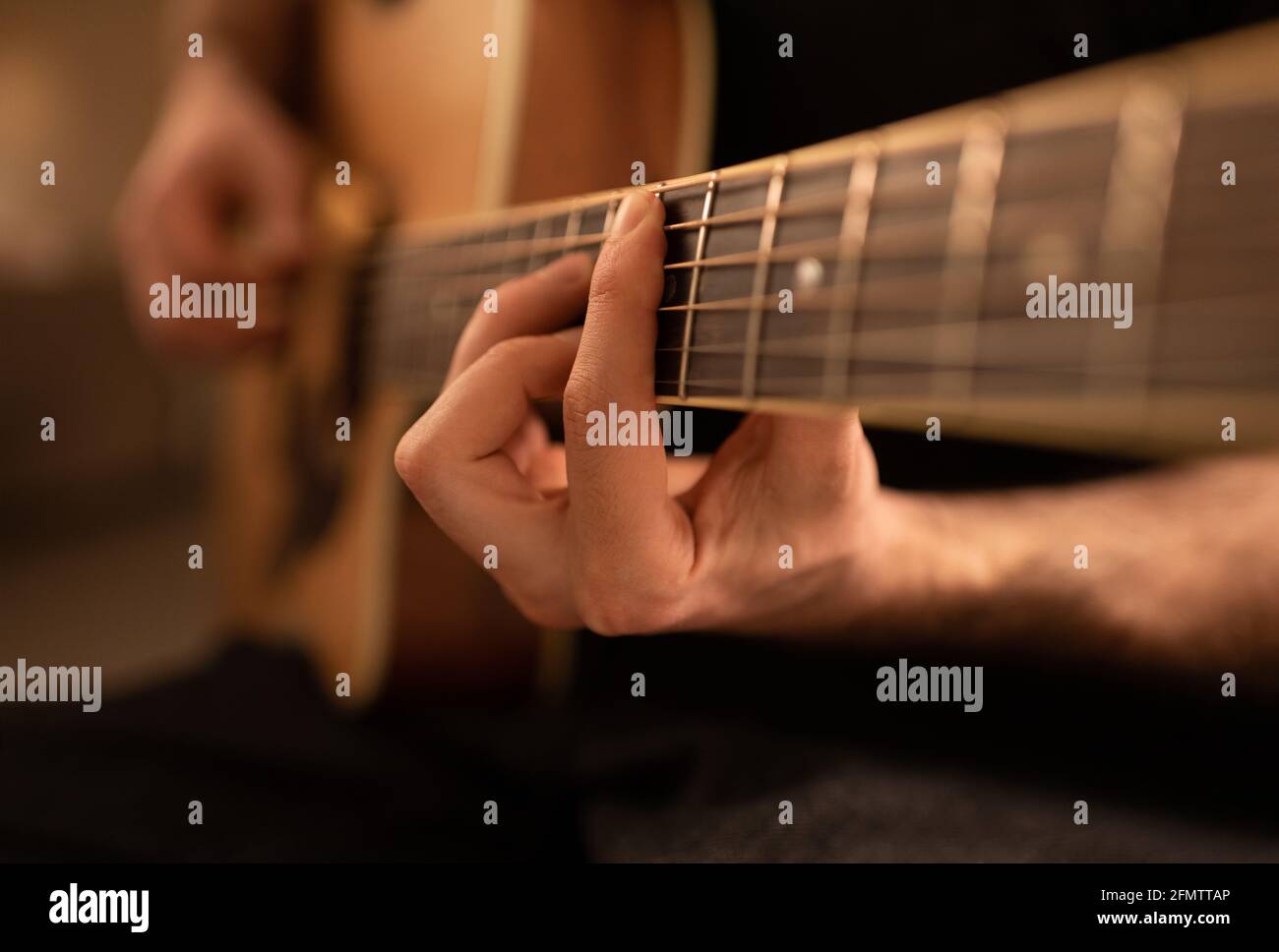 Cropped man playing and tuning guitar Stock Photo
