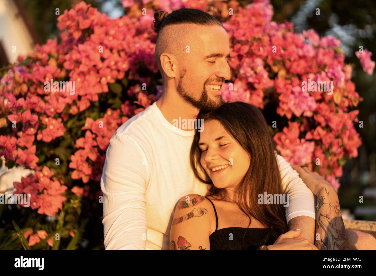 couple in love among flowers hugs and laughs Stock Photo