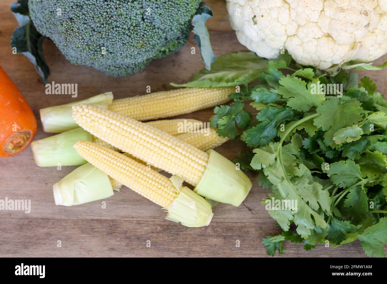 A collection of fresh and delicious vegetables on a wooden table Stock Photo