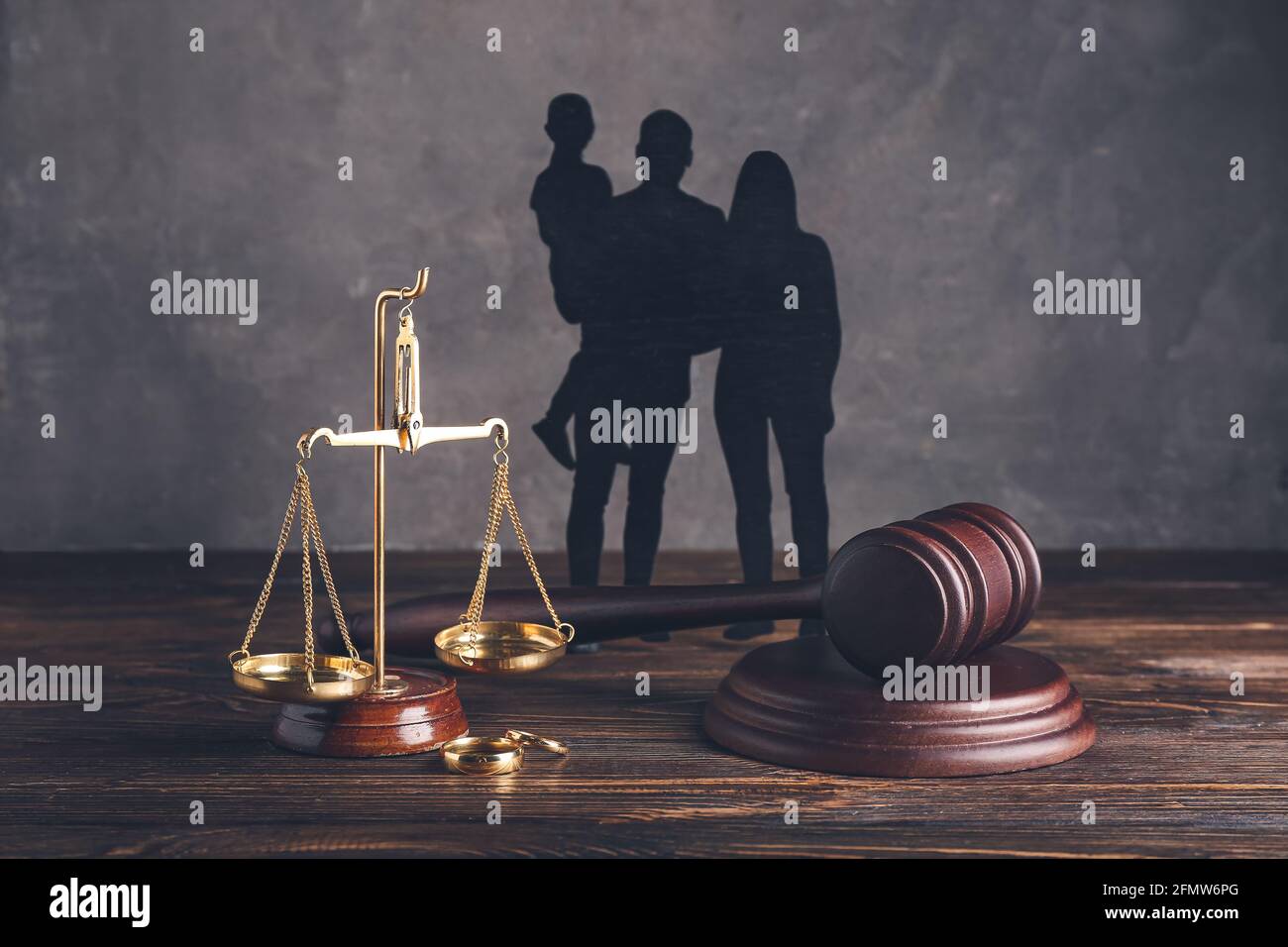 Family figures with judge's gavel and justice scales on dark wooden ...