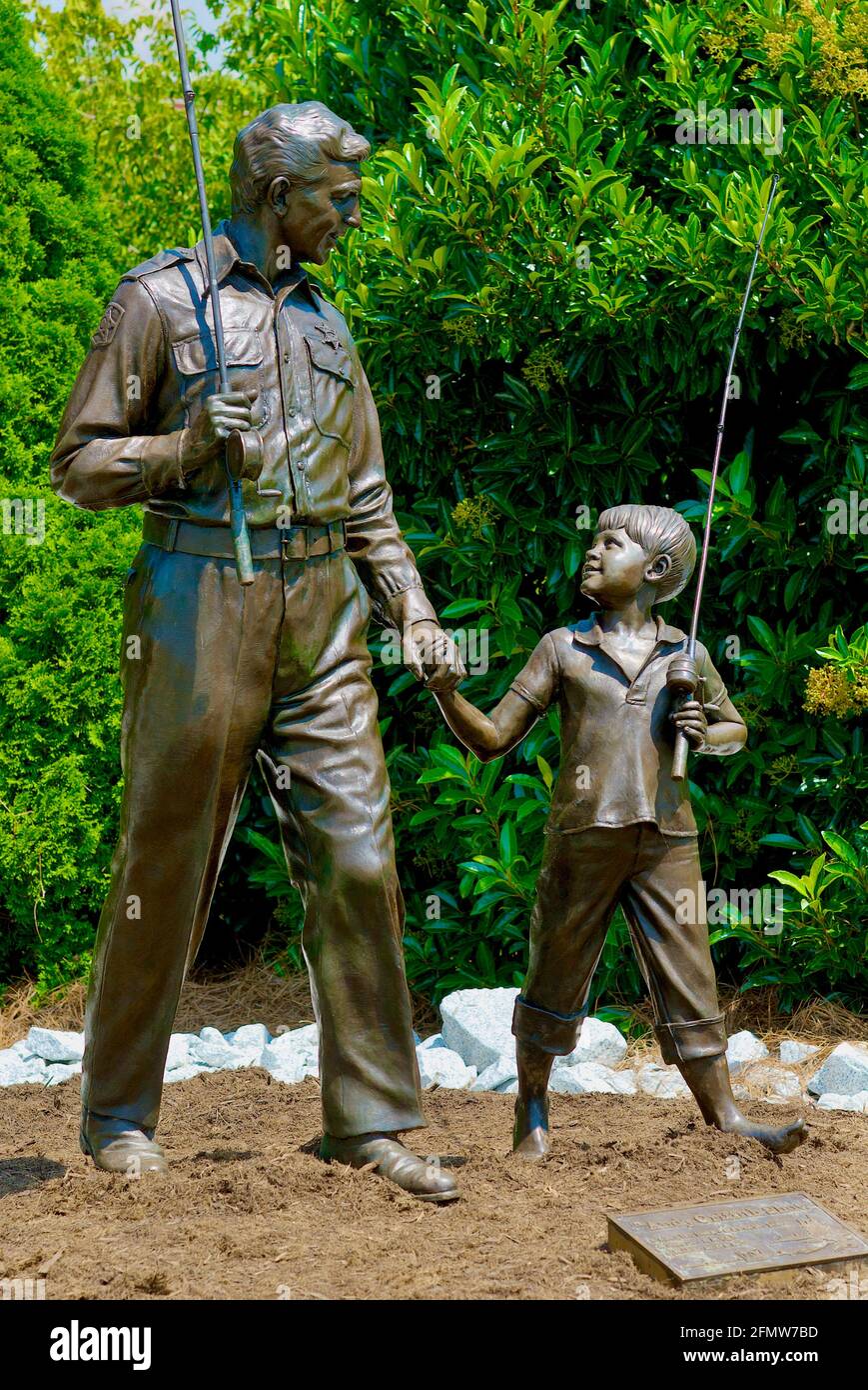 Mount Airy, North Carolina, USA - July 5, 2020: A bronze statue commemorates 'Sheriff Andy and Opie Taylor' of the popular 'The Andy Griffith Show'. Stock Photo