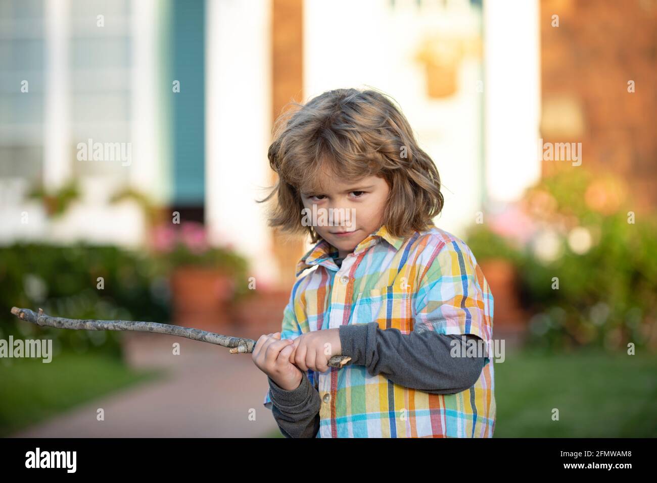 Child aggression. Negative kids emotion. Angry boy with stick. Kid