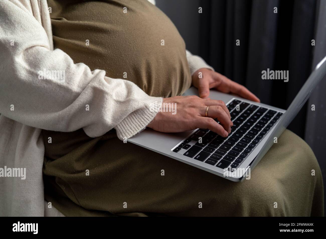 Attractive pregnant young lady working remotely online from home. Close