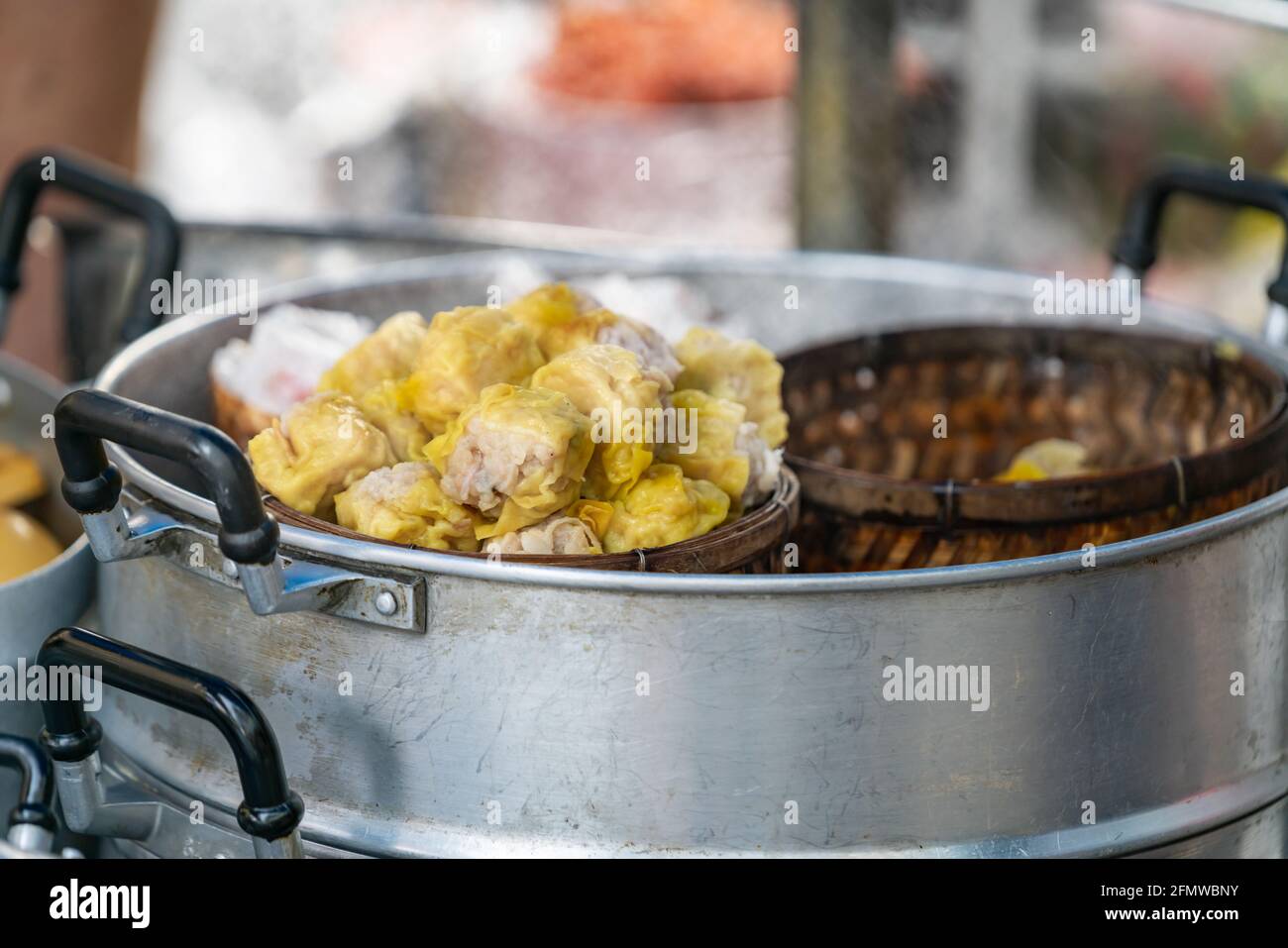 Dim Sum or Chinese dumpling in a stream hot pot of food wheelbarrow on  street food of Bangkok. Many dumpling in a wooden basket is streaming in  old As Stock Photo 