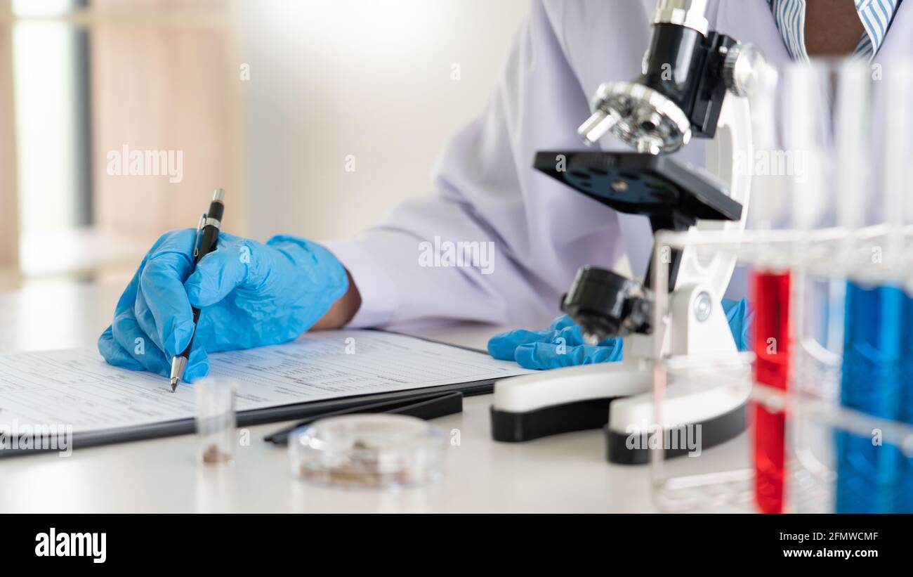 Young Asian scientist Working looking through a microscope doing ...