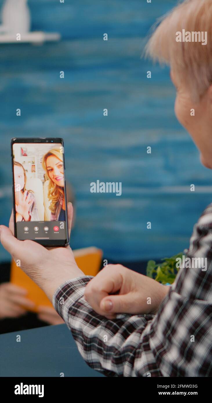 Senior woman having video call online talk with nephew using smartphone ...