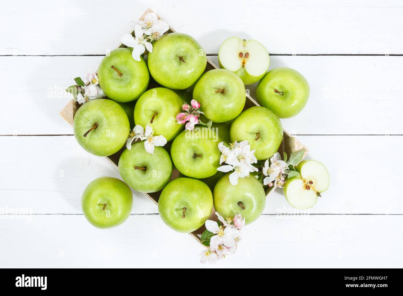 Apples fruits green apple fruit box on wooden board with leaves and blossoms food Stock Photo
