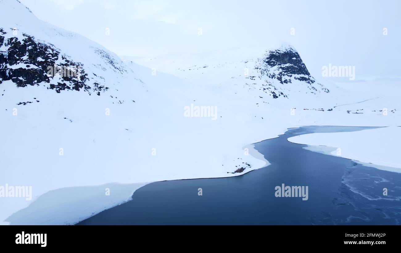 Stunning aerial view of a river flowing through a snow covered tundra. Stock Photo