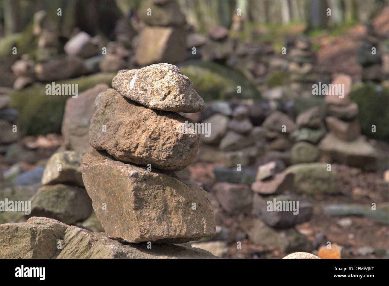 Three Stone Stack stack of three stones in foreground in a forest at a hiking trail Stock ...
