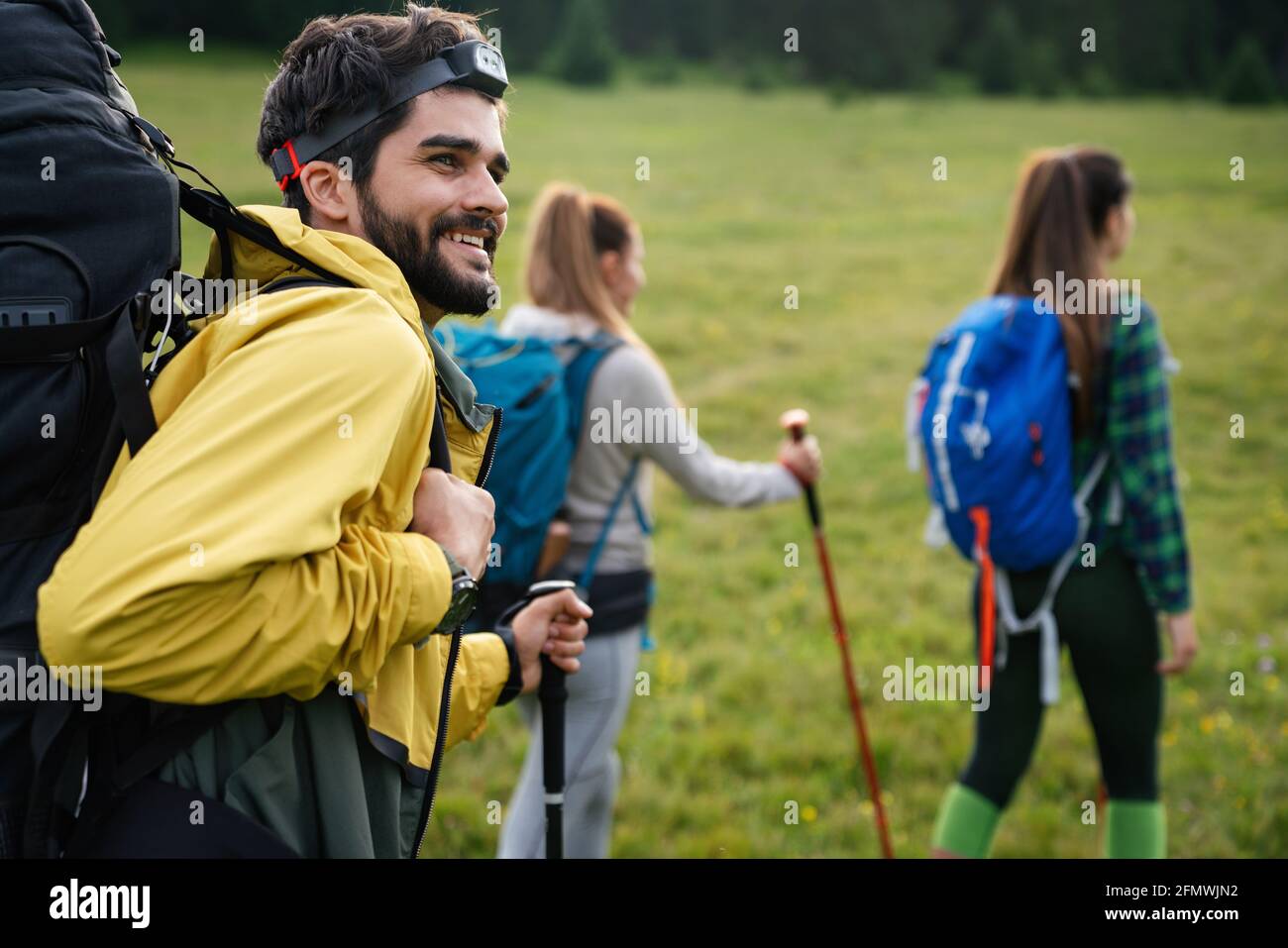 Group of fit healthy friends trekking in the mountains Stock Photo - Alamy