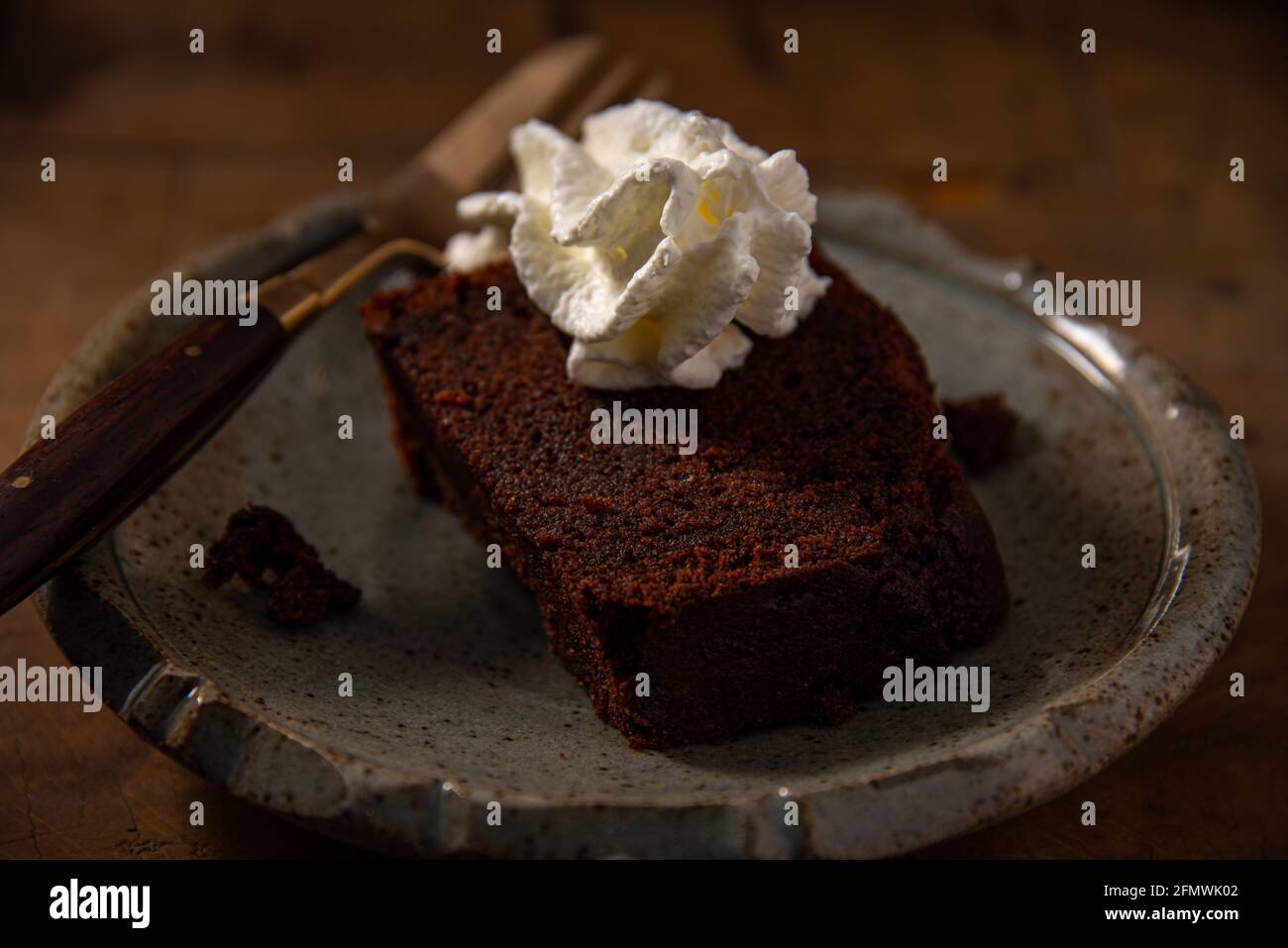 home made chocolate cake or browny with cream on wooden table ,unhealthy eating Stock Photo