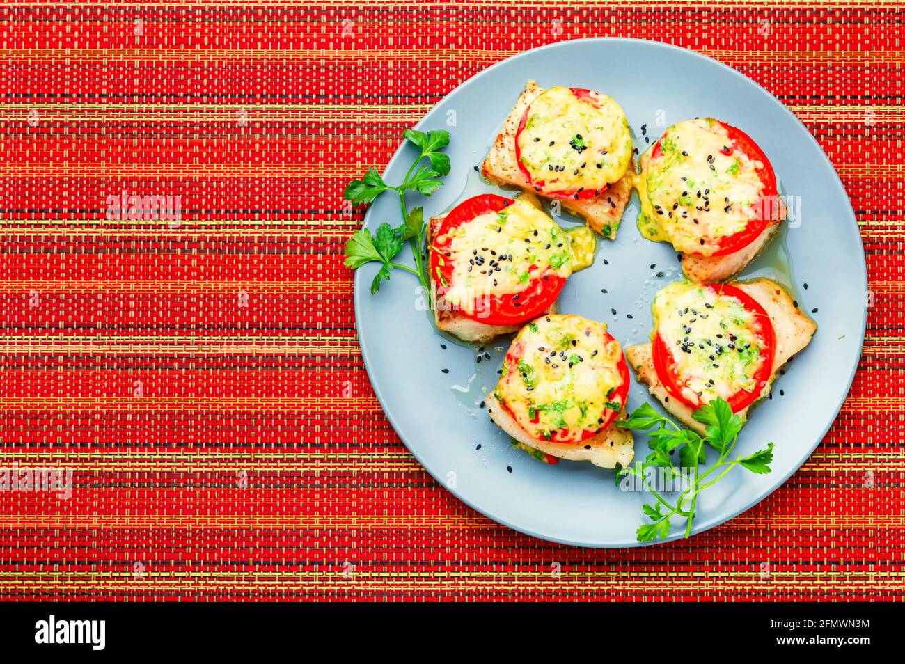 Baked fish with cheese and tomato.Roasted pangasius.Copy space Stock Photo