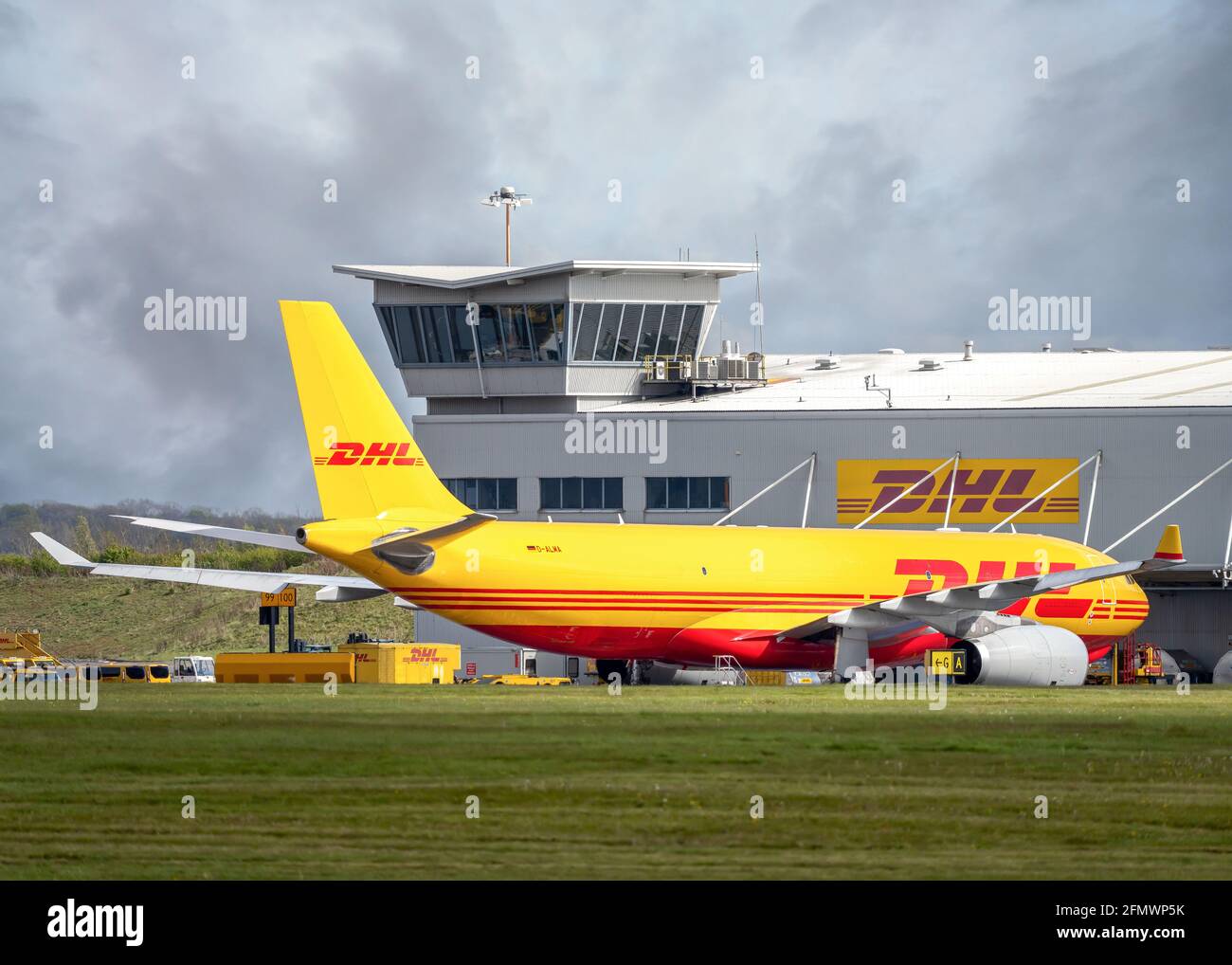 DHL aircraft cargo distribution centre at East Midlands Airport, Leicestershire Yellow Boeing 767 Aeroplane jumbo jet being loaded with packages Stock Photo