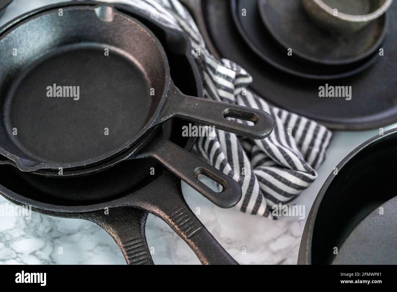Variety of cast iron frying pans on a marble background Stock Photo Alamy