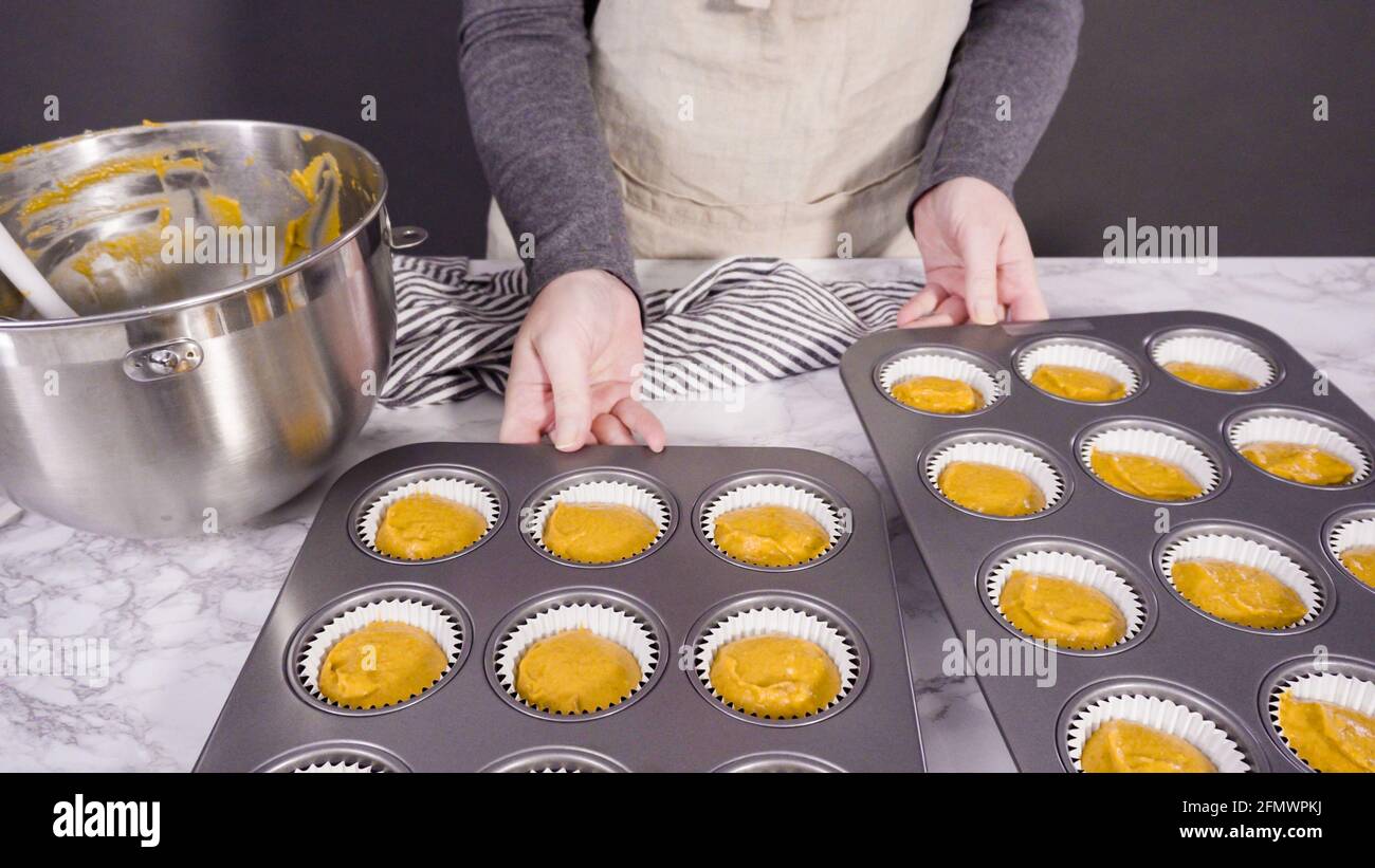 https://c8.alamy.com/comp/2FMWPKJ/scooping-pumpkin-spice-cupcake-batter-with-batter-scoop-into-a-cupcake-pan-with-liners-2FMWPKJ.jpg