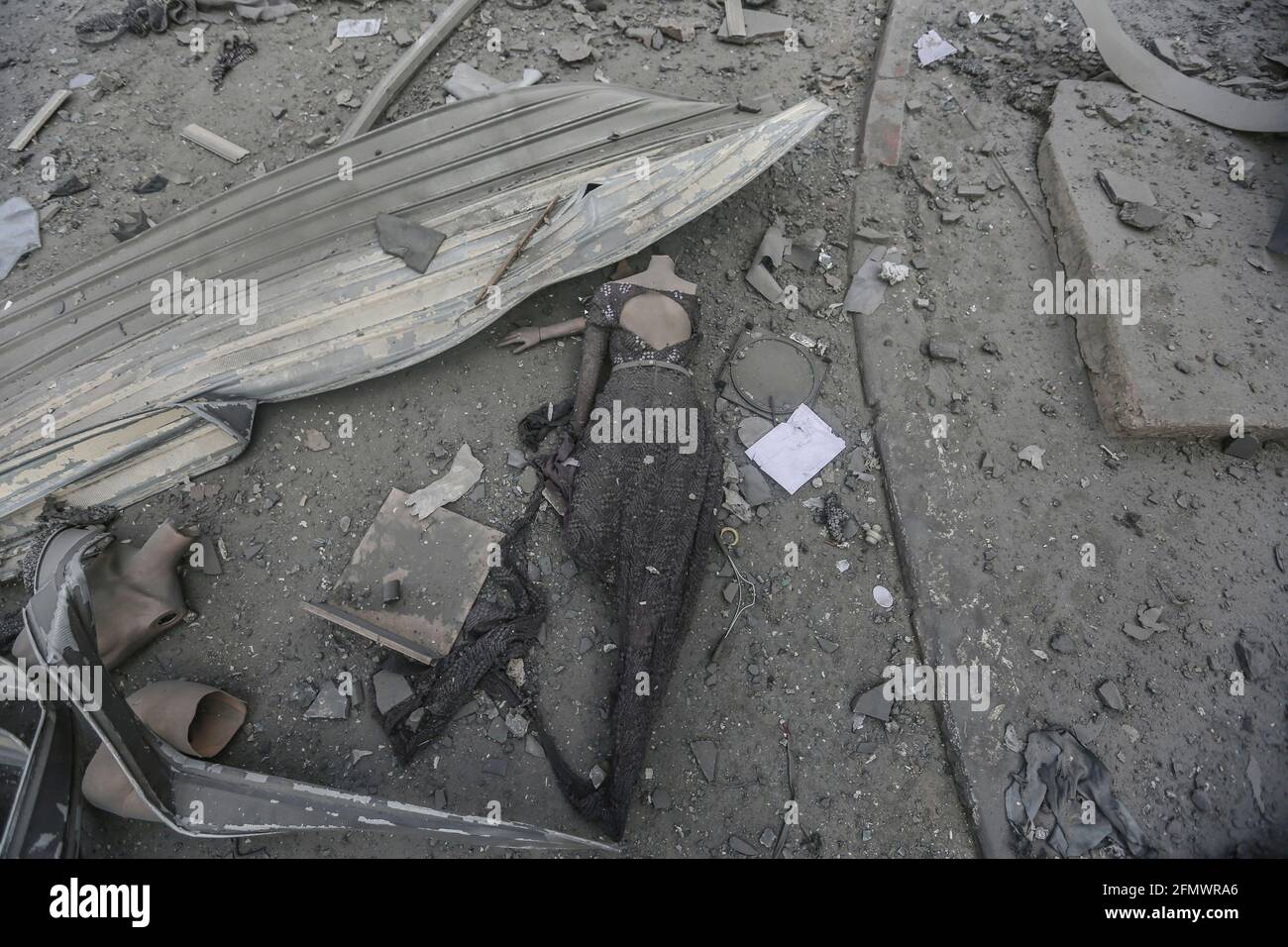 Gaza City, Palestinian Territories. 12th May, 2021. Parts of broken mannequins lie on the ground near the severely damaged Al-Jawhara Tower in Gaza City after it was hit by Israeli airstrikes amid the escalating flare-up of Israeli-Palestinian violence. The Health Ministry in the Hamas-run Gaza Strip said the number of Palestinians killed has risen to 35, including 12 children, while 233 people were reported injured. Credit: Mohammed Talatene/dpa/Alamy Live News Stock Photo