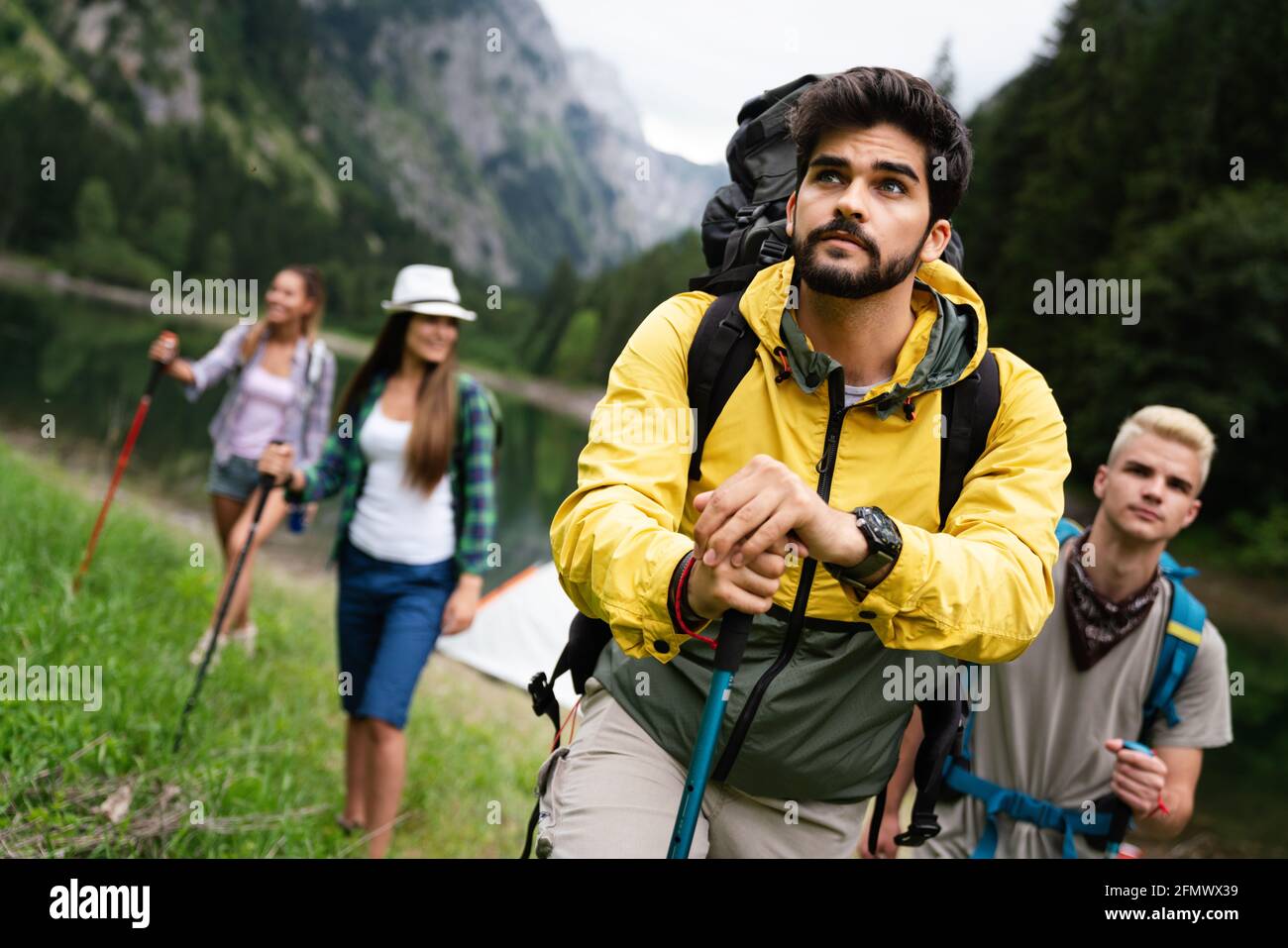 Group of young friends hiking in countryside. Multiracial happy people ...