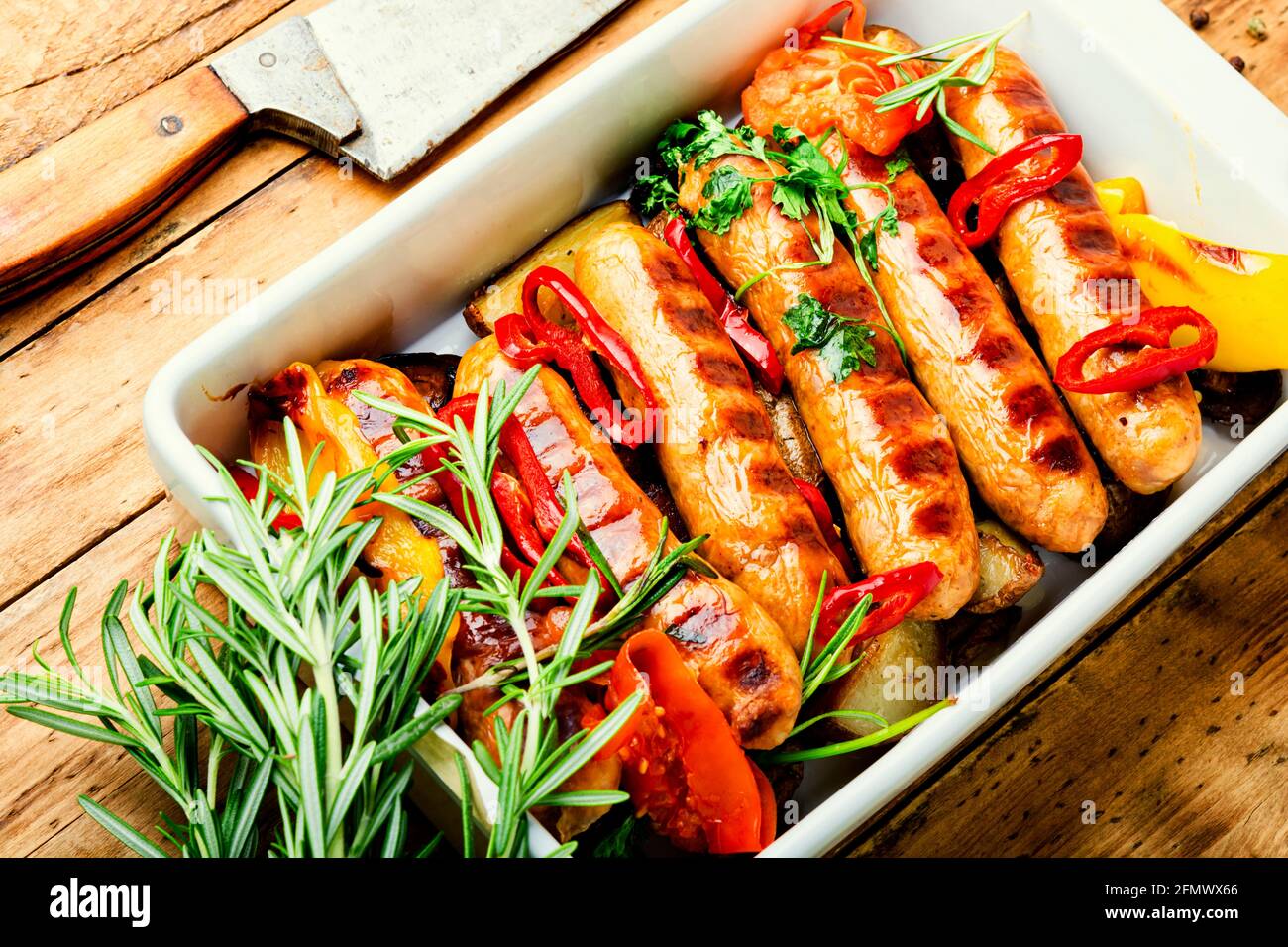 Fried sausages with potatoes and vegetables in a baking dish Stock