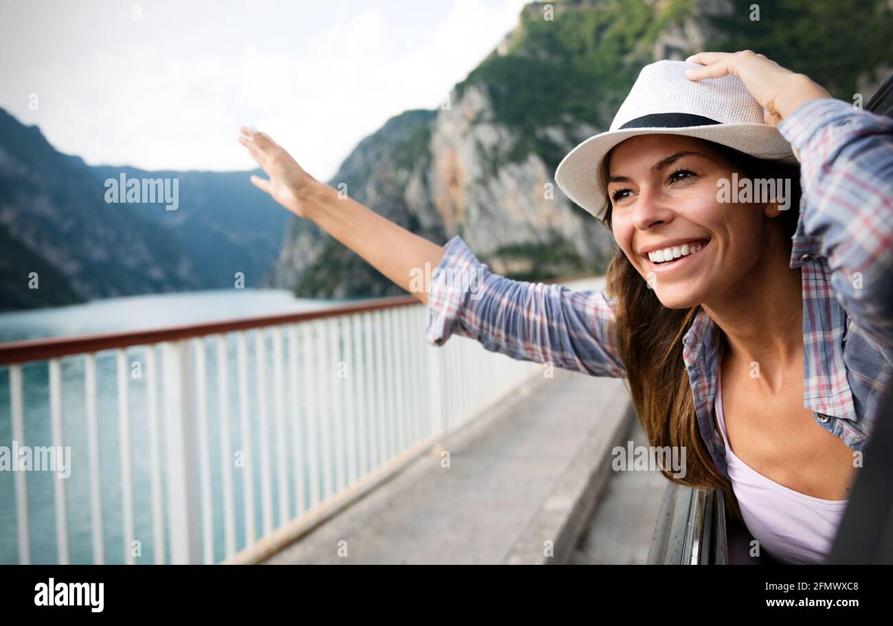 Woman in car road trip waving out the window smiling Stock Photo - Alamy