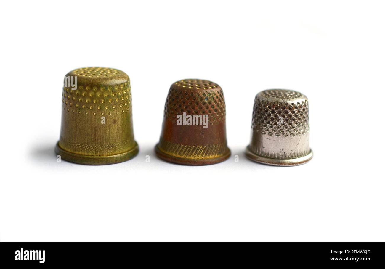 Three vintage thimbles stand in a row isolated on a white background Stock Photo Alamy
