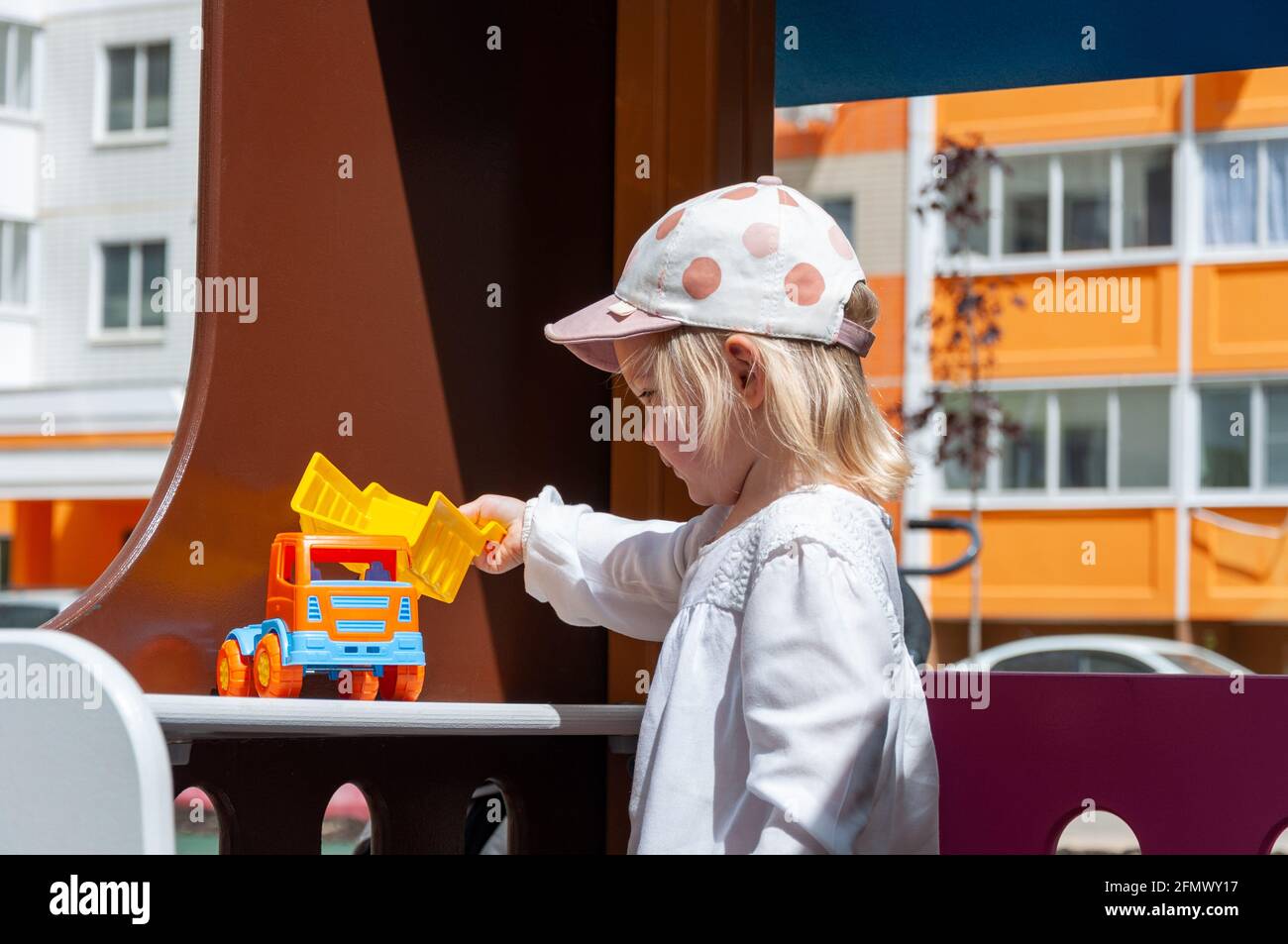 Girl Playing With Toy Outdoor. Kid playing with tiny car on the