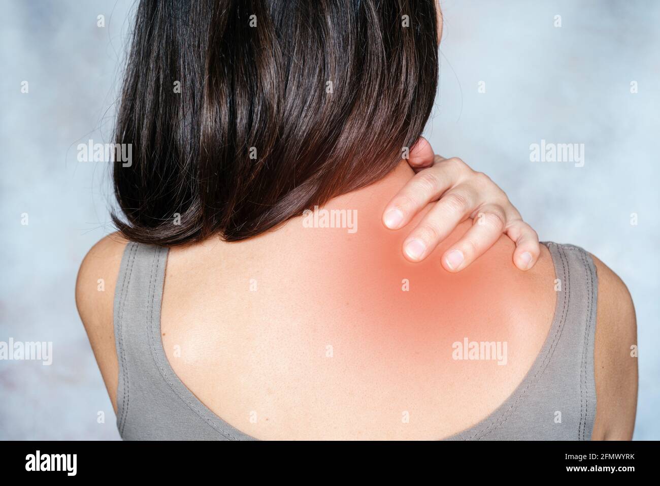 A woman massages her shoulder and neck pain points, trigger point