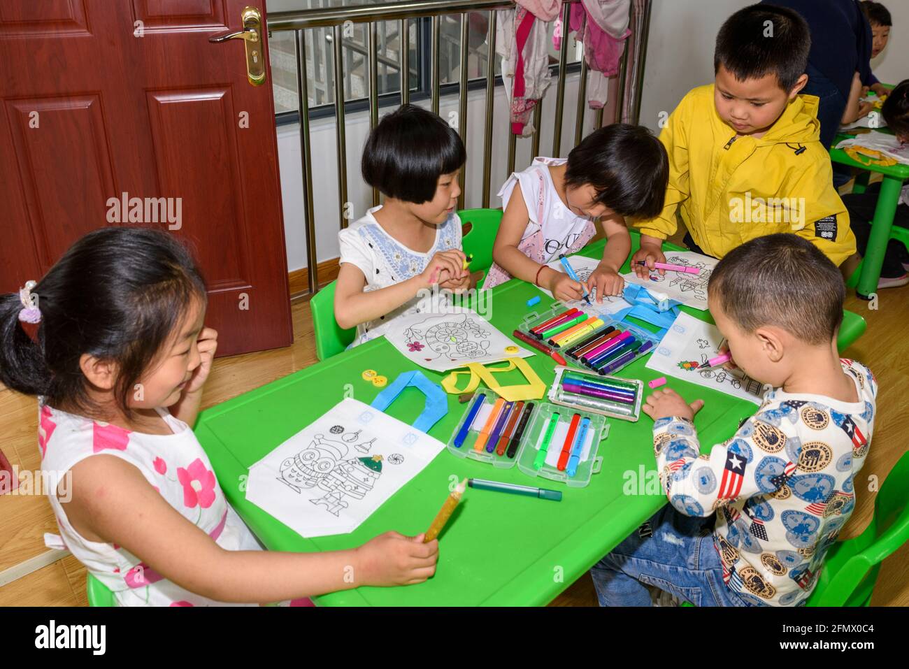 Primary students at a rural school in Xiuning, Anhui, China decorating their canvas bags. Stock Photo