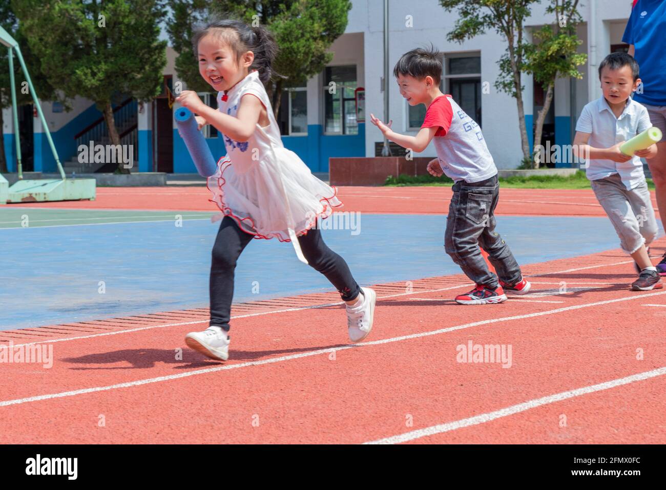 Kindergarten students from the Weiqiao Central Primary school in Xiuning, Anhui, China participate in a relay competition Stock Photo