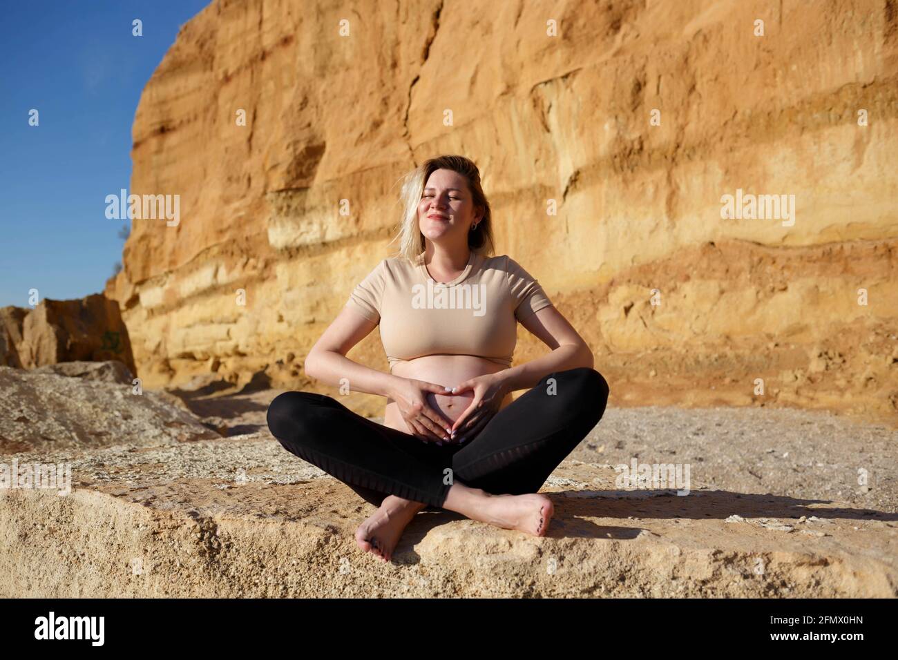 Pregnant woman sitting on rock hi-res stock photography and images - Alamy