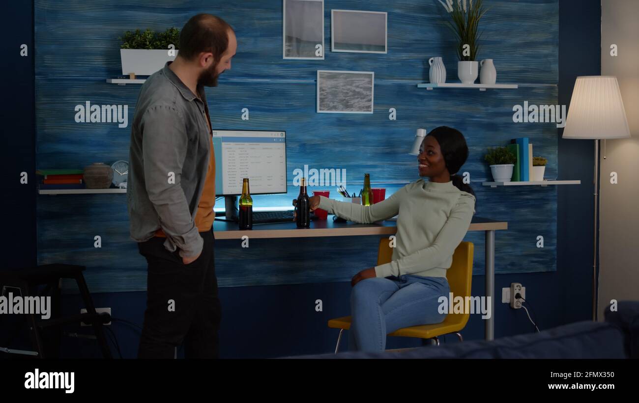 Happy man greeting his mixed race friends while talking with black ...
