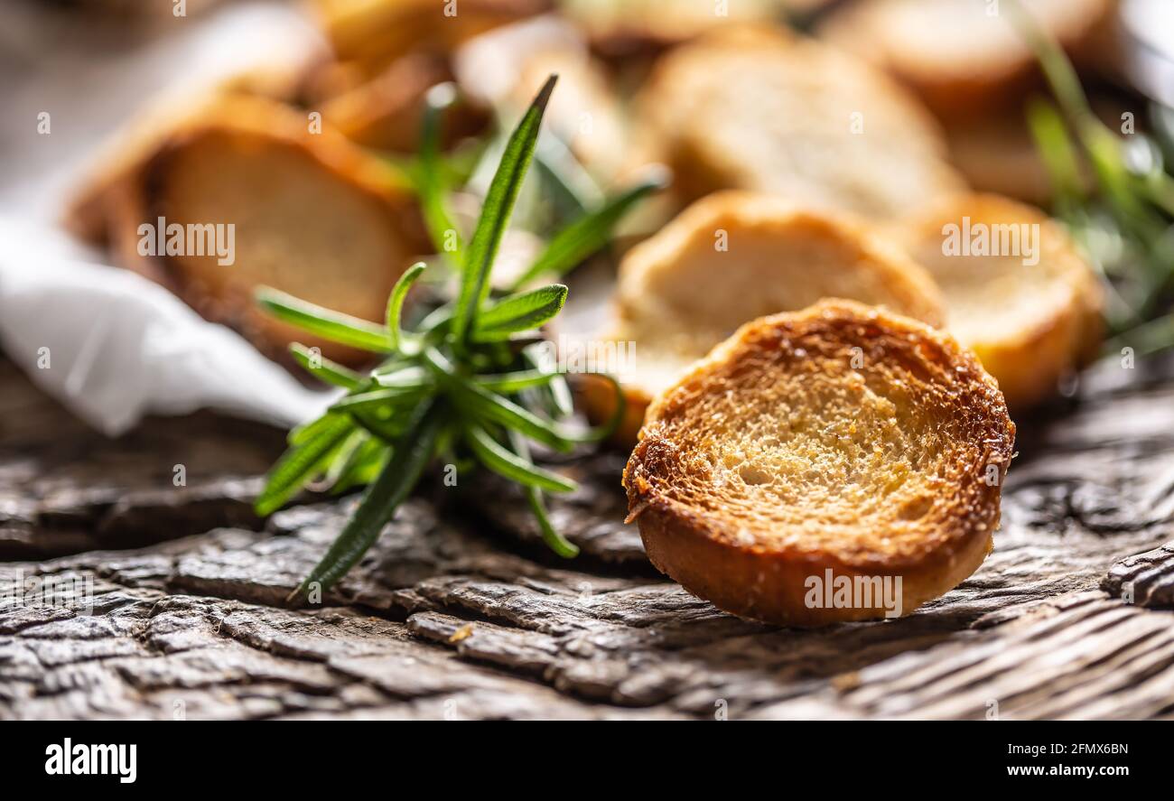 Crunchy and savory bake rolly with goldish color served in the paper with fresh green rosemary. Stock Photo
