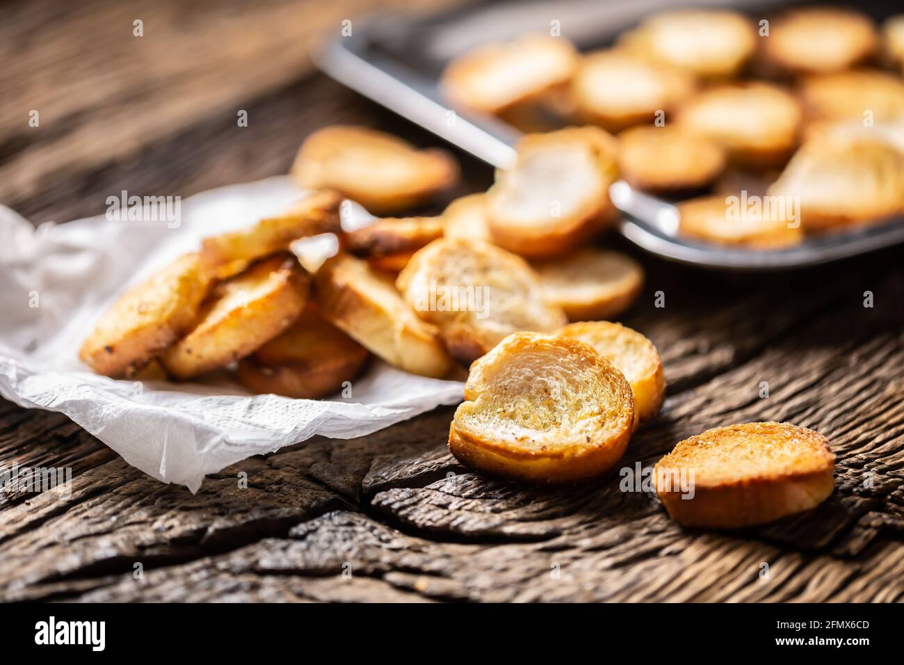 Freshly baked crispy bake rolls with goldish colour served in the paper on  a rustic wooden desk Stock Photo - Alamy