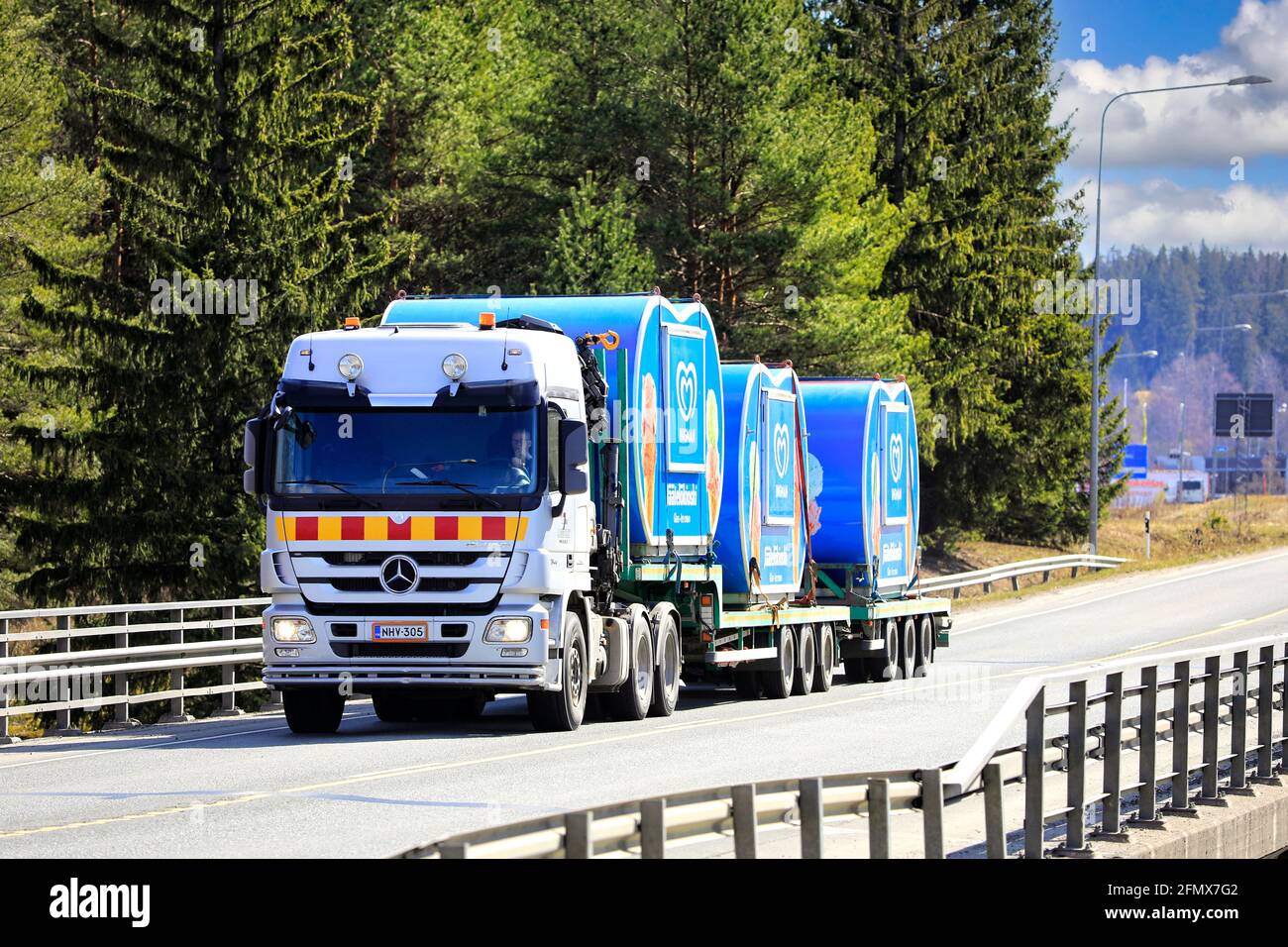 Mercedes-Benz Actros truck hauling three Ingman ice cream kiosks on semi trailer on a sunny day of spring. Highway 2, Forssa, Finland. April 29, 2021. Stock Photo