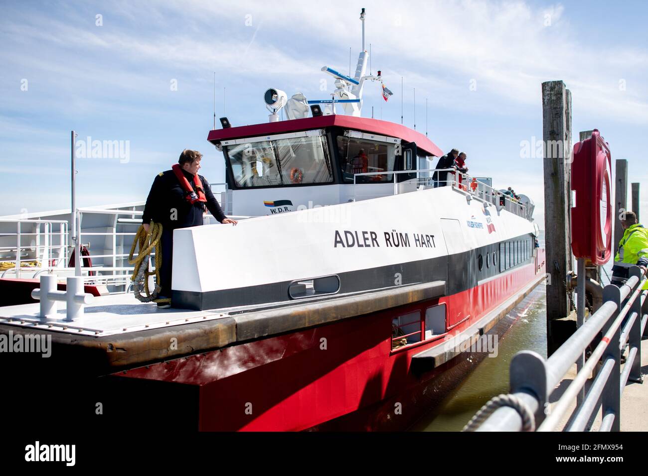 Norderney, Germany. 12th May, 2021. The catamaran MV 'Adler Rüm Hart' moors at a quay in the harbour of the island of Norderney. AG Reederei Norden-Frisia is testing the use of a fast catamaran in passenger traffic on the route between Norddeich and Norderney. The three-day pilot project is initially intended to supplement the regular ferry service. Credit: Hauke-Christian Dittrich/dpa/Alamy Live News Stock Photo