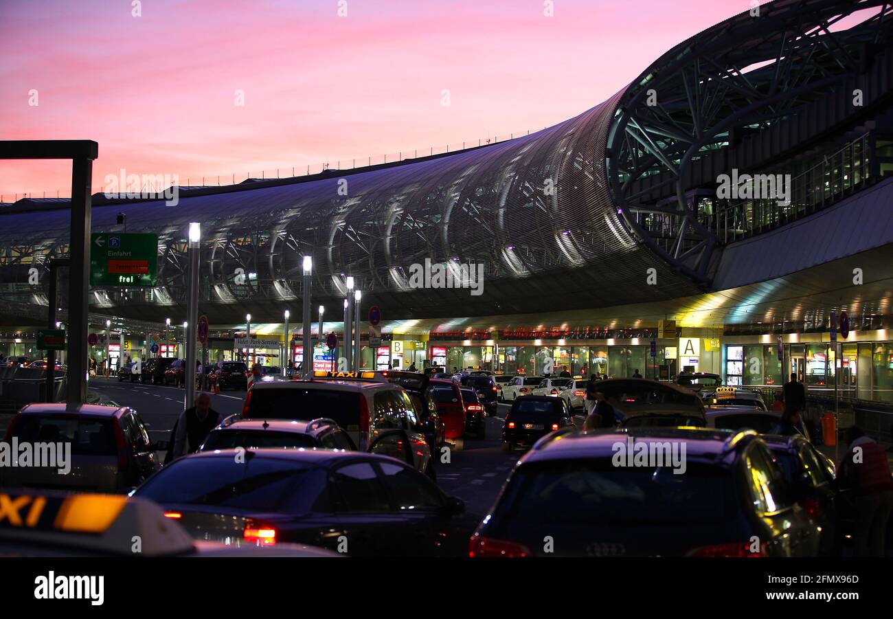 Der Flughafen Düsseldorf in der Abenddämmerung. Der rötliche Himmel bildet einen schönen Kontrast zu neuzeitlichen Architektur des Airports. Stock Photo