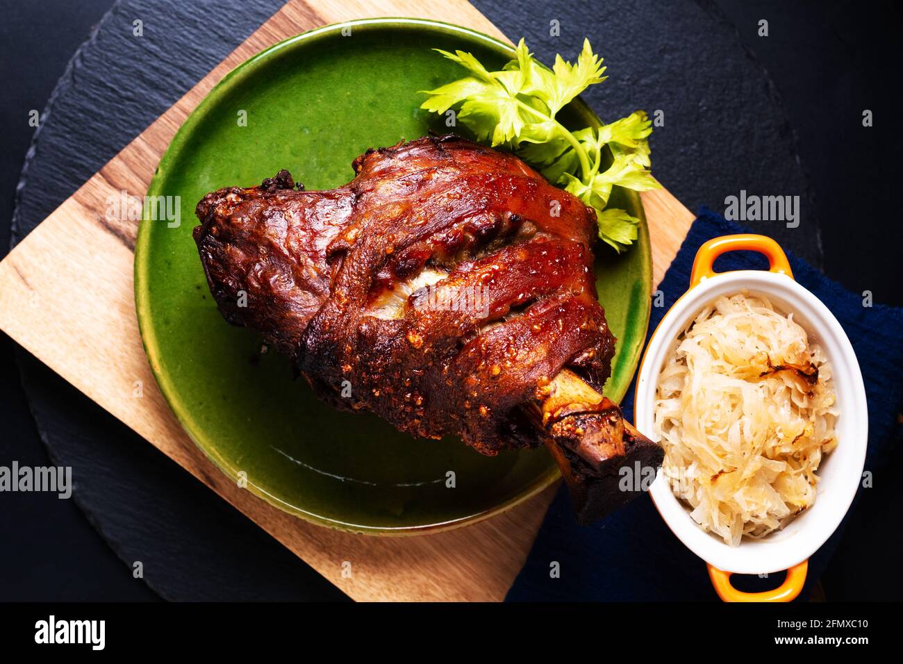 Food concept German pork hock or pork knuckle with sauerkraut cabbage pickle on wooden board with copy space Stock Photo