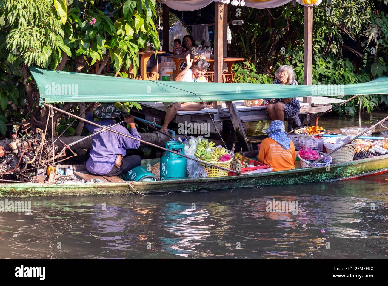 Longtail boat delivering food to riverside residents on Khlong, Bangkok, Thailand Stock Photo
