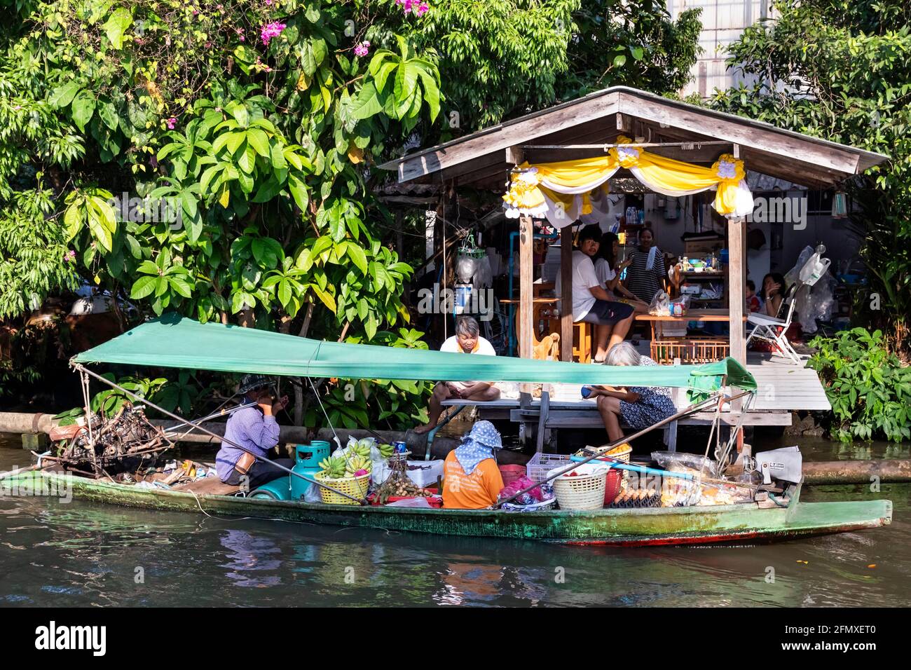 Longtail boat delivering food to riverside residents on Khlong, Bangkok, Thailand Stock Photo