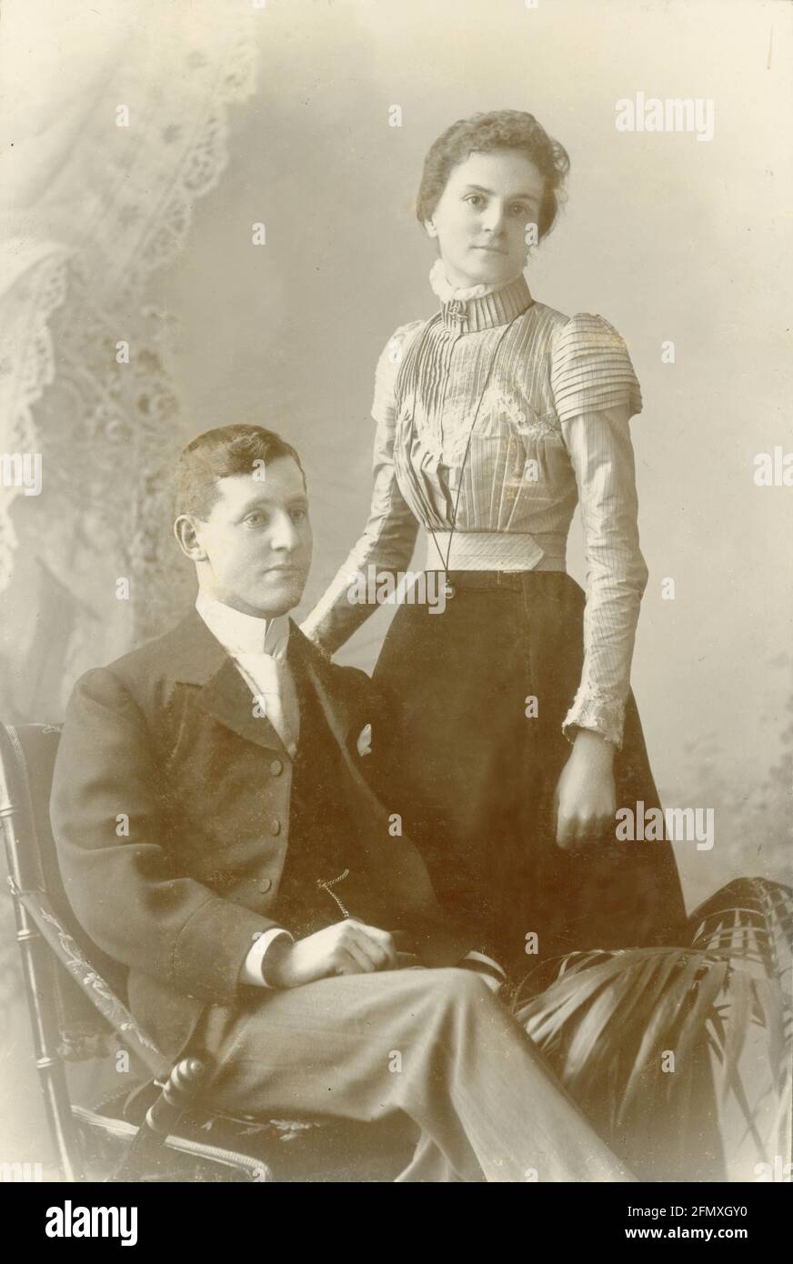 Original faded early Edwardian cabinet card of young married couple, from William Harrison studios, Falmouth, Cornwall, UK dated circa 1902 Stock Photo