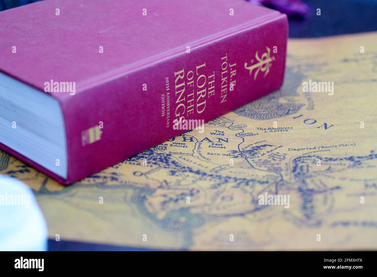 Red thick Lord of the Rings book lies on Middle-Earth map Stock Photo