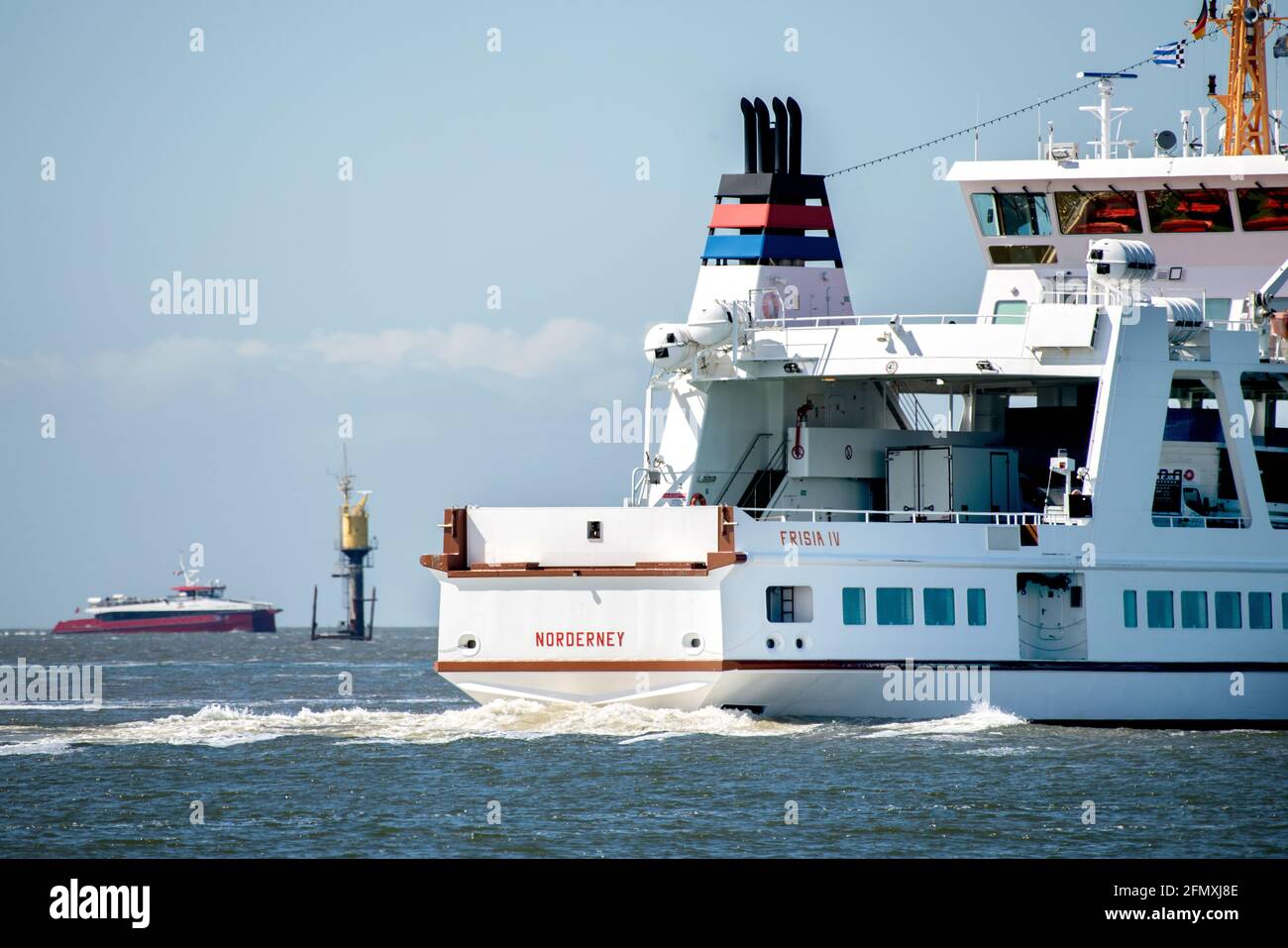 Norderney, Germany. 12th May, 2021. The ferry 'Frisia IV' is underway in the Wadden Sea off the island of Norderney, while in the background the catamaran MV 'Adler Rüm Hart' approaches the island. AG Reederei Norden-Frisia is testing the use of a fast catamaran in passenger traffic on the route between Norddeich and Norderney. The three-day pilot project is initially intended to supplement the regular ferry service. Credit: Hauke-Christian Dittrich/dpa/Alamy Live News Stock Photo
